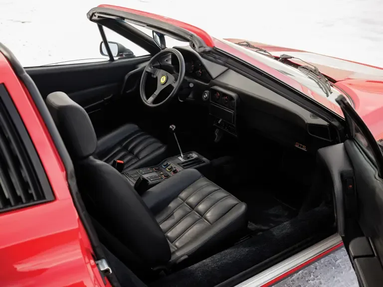 Offener Innenraum eines Ferrari 328 GTS von 1988 mit schwarzem Leder und Targadach