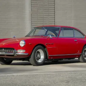 Ferrari 330 GT 2+2 Serie II Baujahr 1966 in Rot, Seitenansicht vor einer grauen Mauer, klassisches Coupé mit stilvollem Design.