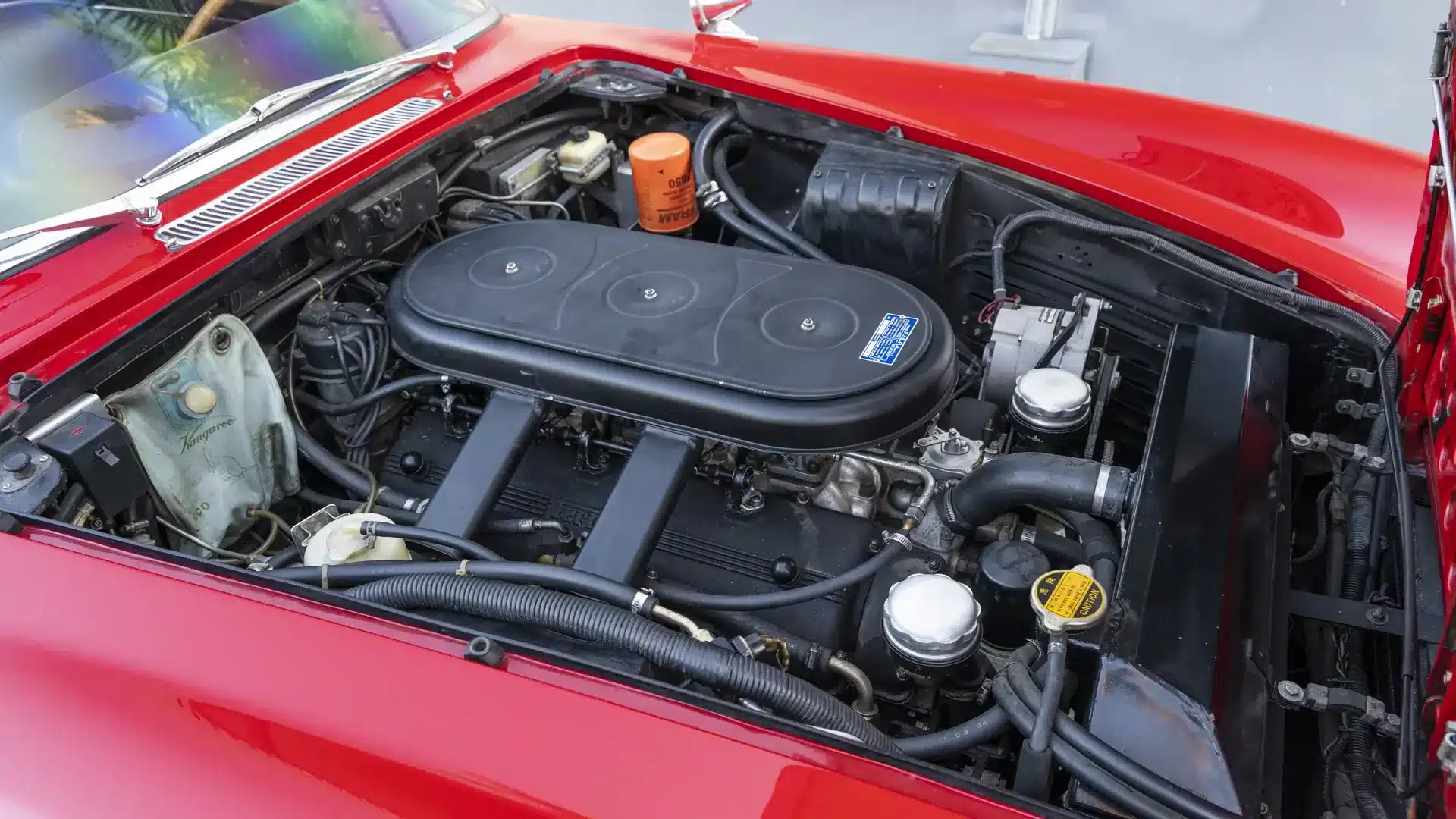 Ferrari 330 GT 2+2 V12-Motor aus dem Jahr 1966 im Motorraum, restauriert, mit roten Karosserieteilen