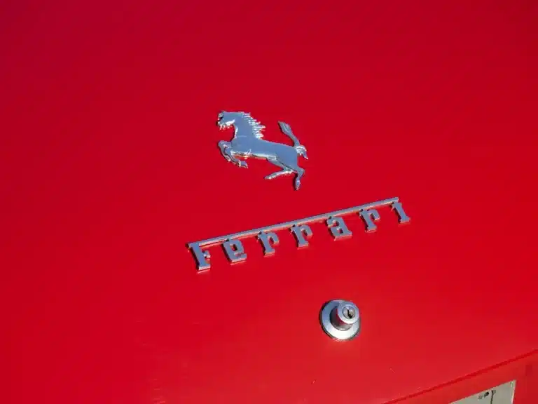 Ferrari-Schriftzug und springendes Pferd auf rotem Fahrzeugheck des Ferrari 330 GT 2+2