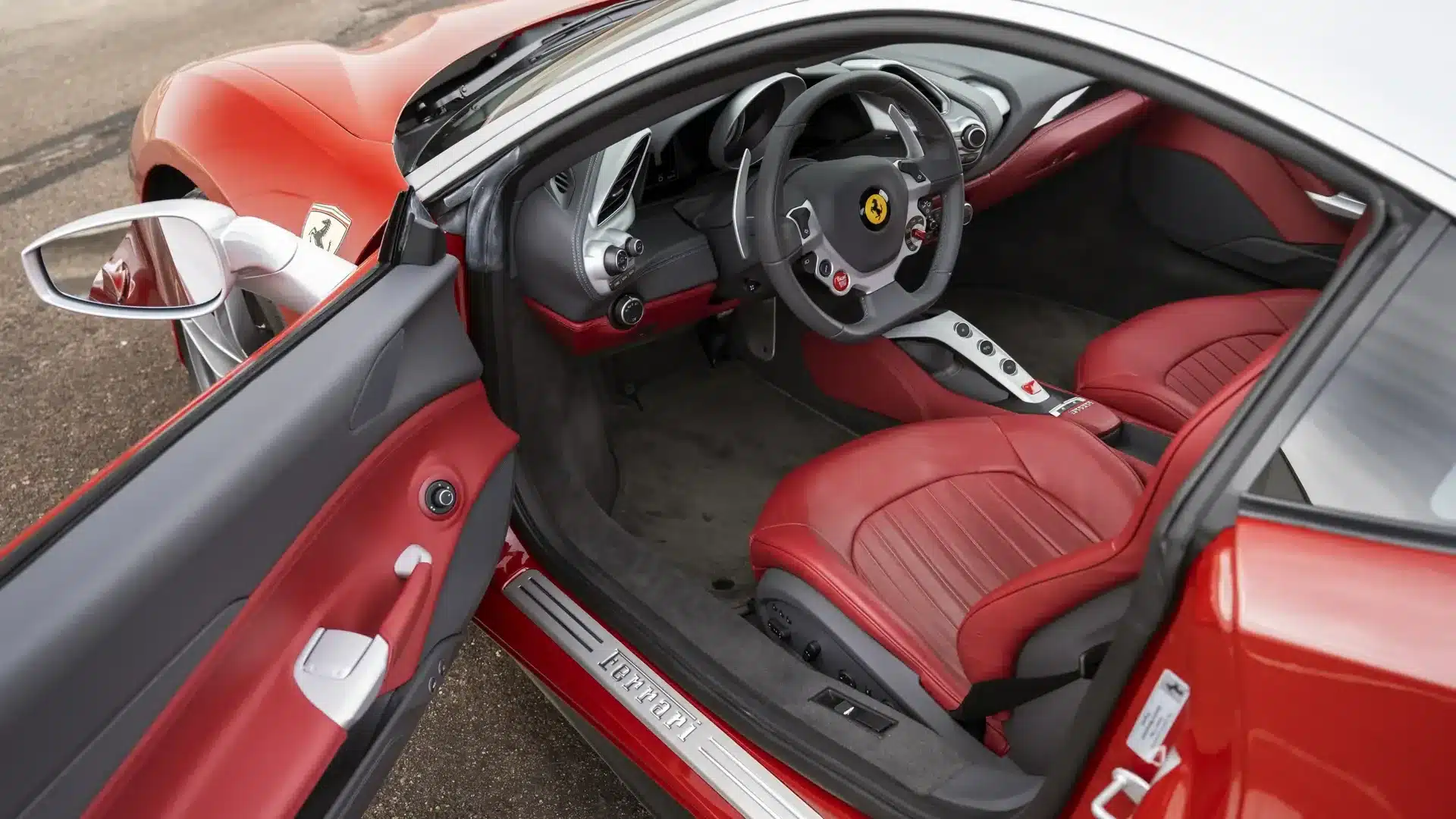 Offene Fahrertür des Ferrari 488 GTB 70th Anniversary mit sichtbarem Interieur in Rot und Grau sowie Aluminiumdetails.