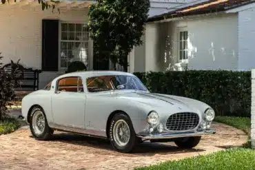 Ferrari 250 Europa GT Coupé von 1955 in silber-grau mit Pinin-Farina-Karosserie, geparkt vor einer weißen Villa.