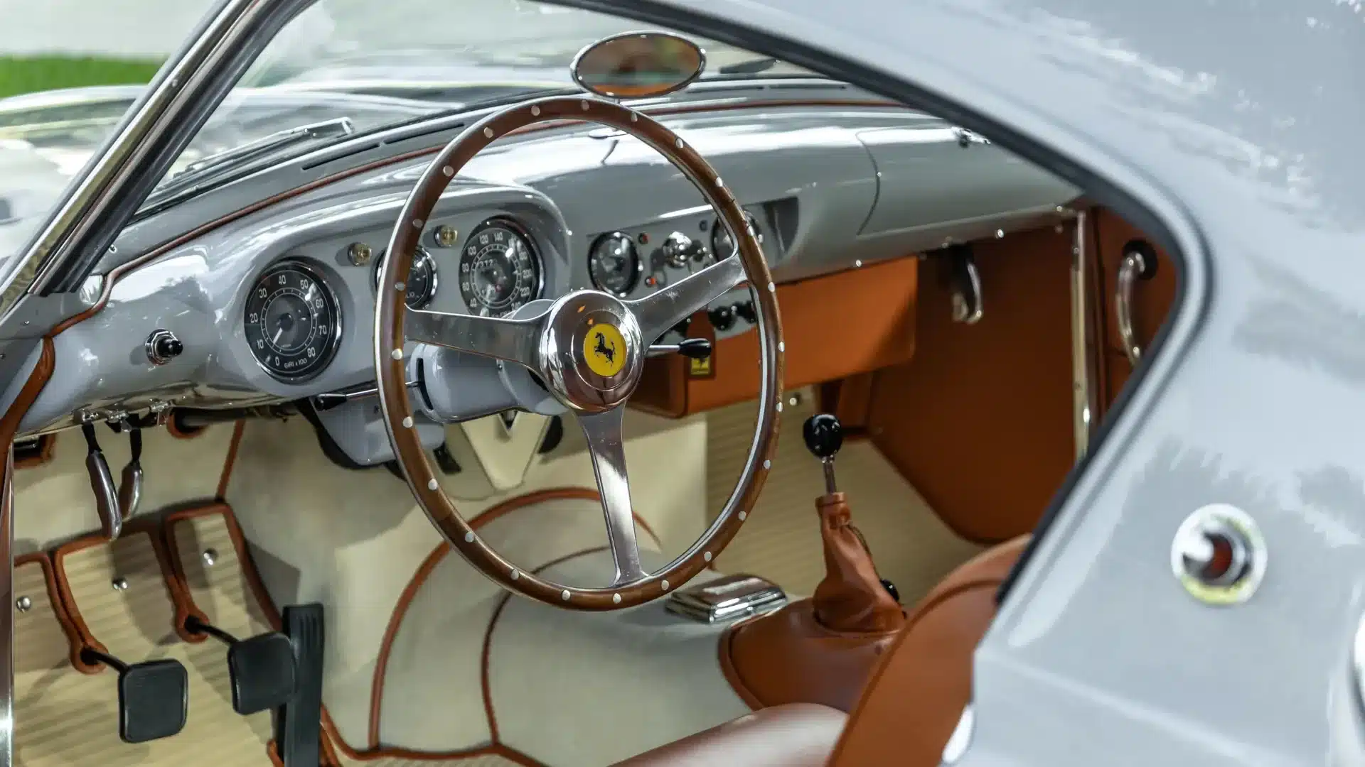 Innenaufnahme des Ferrari 250 Europa GT Coupé von 1955 mit braunem Lederinterieur und Holzlenkrad.