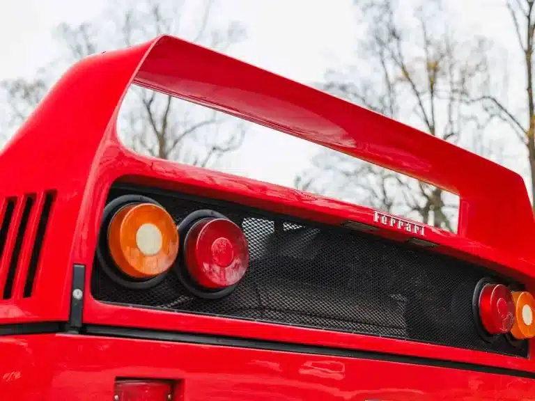 Detailansicht des hinteren Endes eines roten Ferrari F40, mit sichtbarem Heckflügel und Rückleuchten