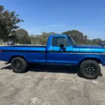 Blauer Ford F-250 Pick-up, Baujahr 1978, Seitenansicht auf freiem Parkplatz