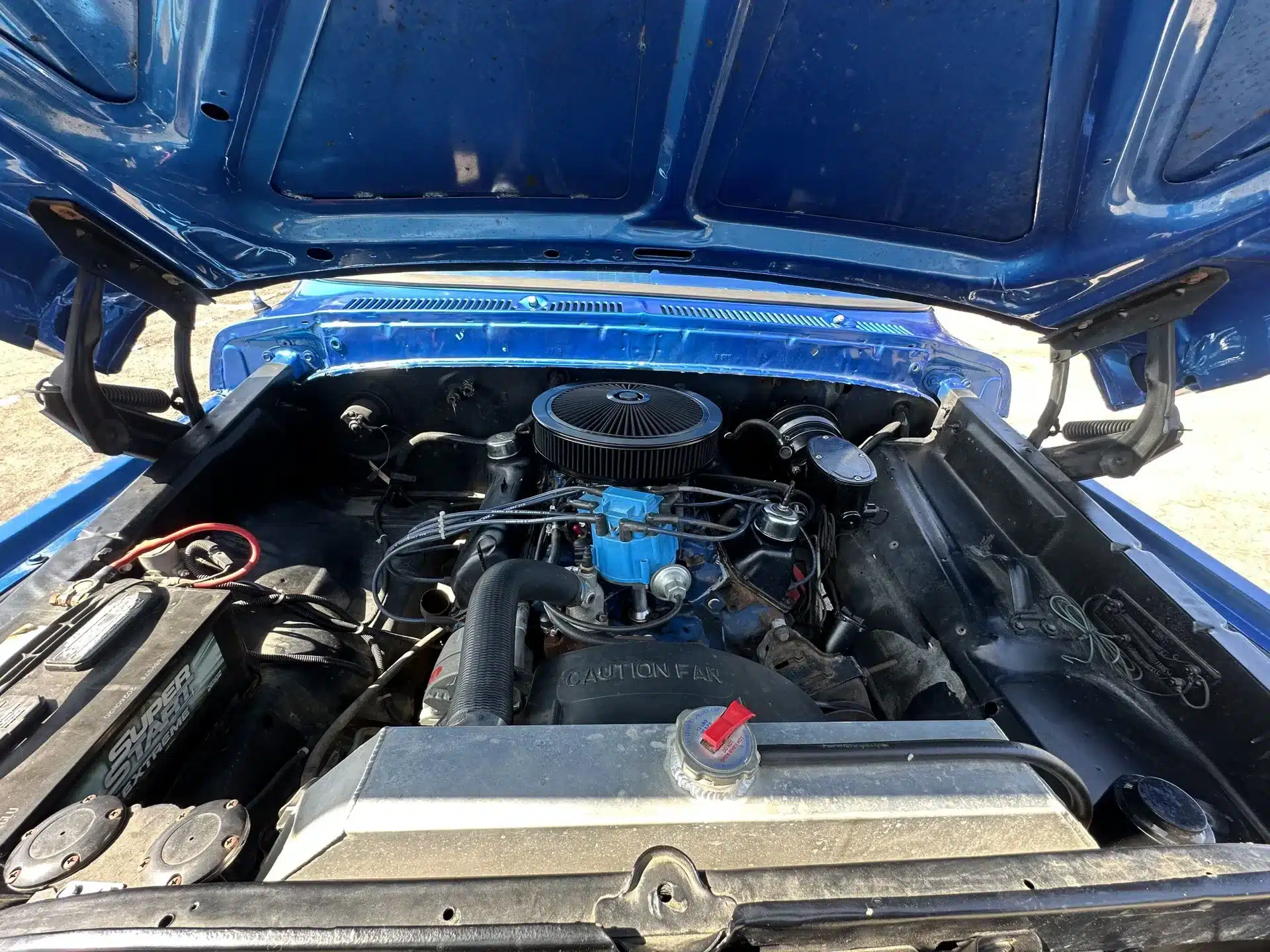 Motorraum eines blauen Ford F-250 von 1978 mit eingebautem V8-Motor