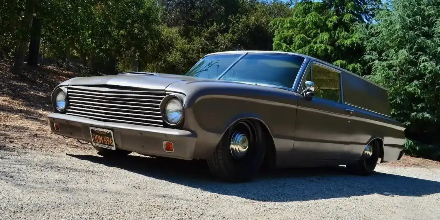 Mattschwarzer Ford Falcon 1963 Panel Sedan Delivery mit Tieferlegung, geparkt im Grünen