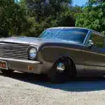 Mattschwarzer Ford Falcon 1963 Panel Sedan Delivery mit Tieferlegung, geparkt im Grünen