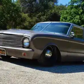 Mattschwarzer Ford Falcon 1963 Panel Sedan Delivery mit Tieferlegung, geparkt im Grünen