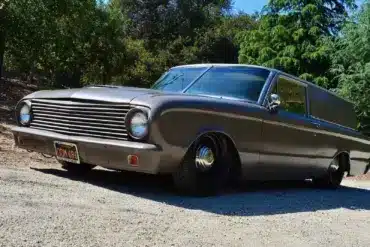 Mattschwarzer Ford Falcon 1963 Panel Sedan Delivery mit Tieferlegung, geparkt im Grünen