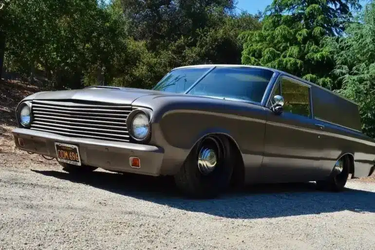 Mattschwarzer Ford Falcon 1963 Panel Sedan Delivery mit Tieferlegung, geparkt im Grünen