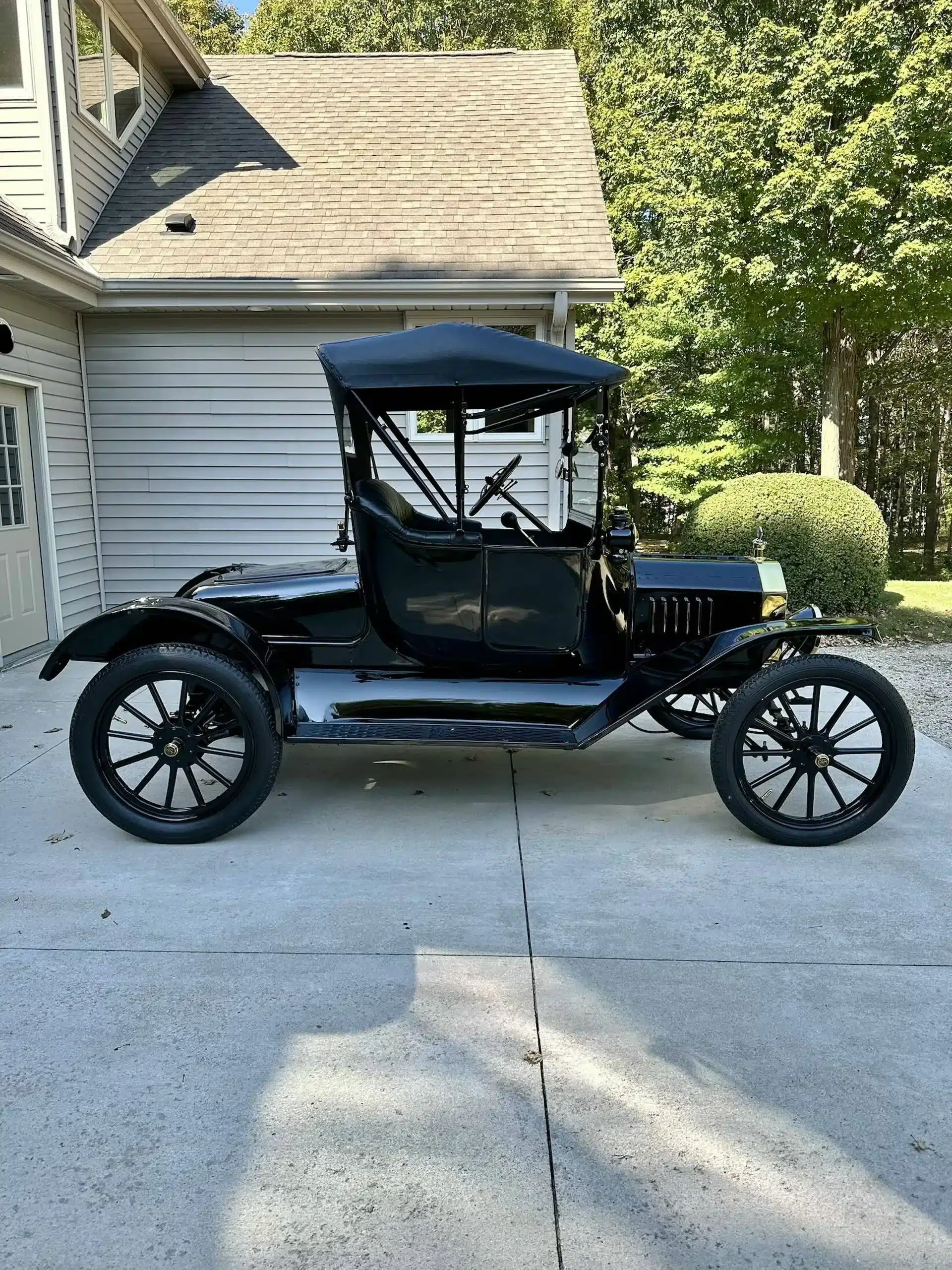 Restauriertes Ford Model T Runabout Baujahr 1915, stehendes Seitenprofil auf einer Einfahrt.