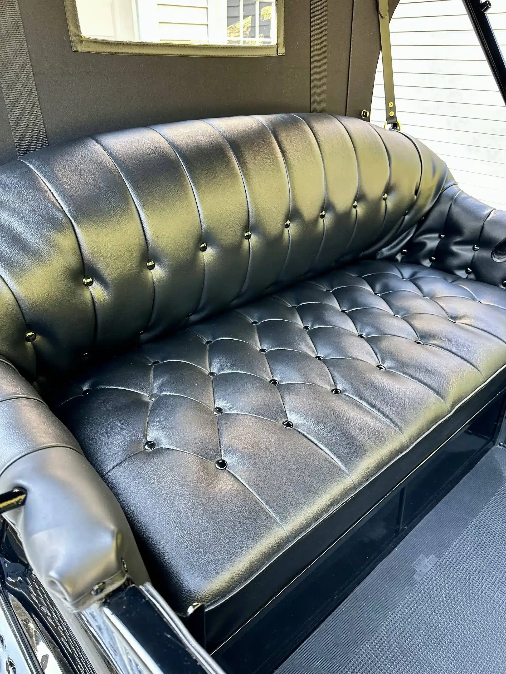 Restaurierte schwarze Ledersitzbank eines Ford Model T Runabout von 1915, Nahaufnahme im Innenraum