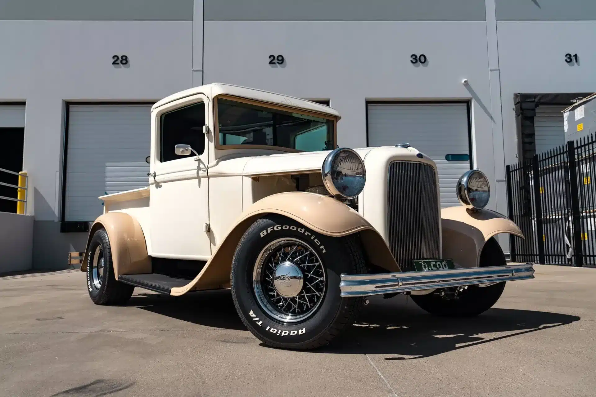 Restaurierter Ford Pickup von 1932 in Creme und Braun vor einem Industriegebäude.