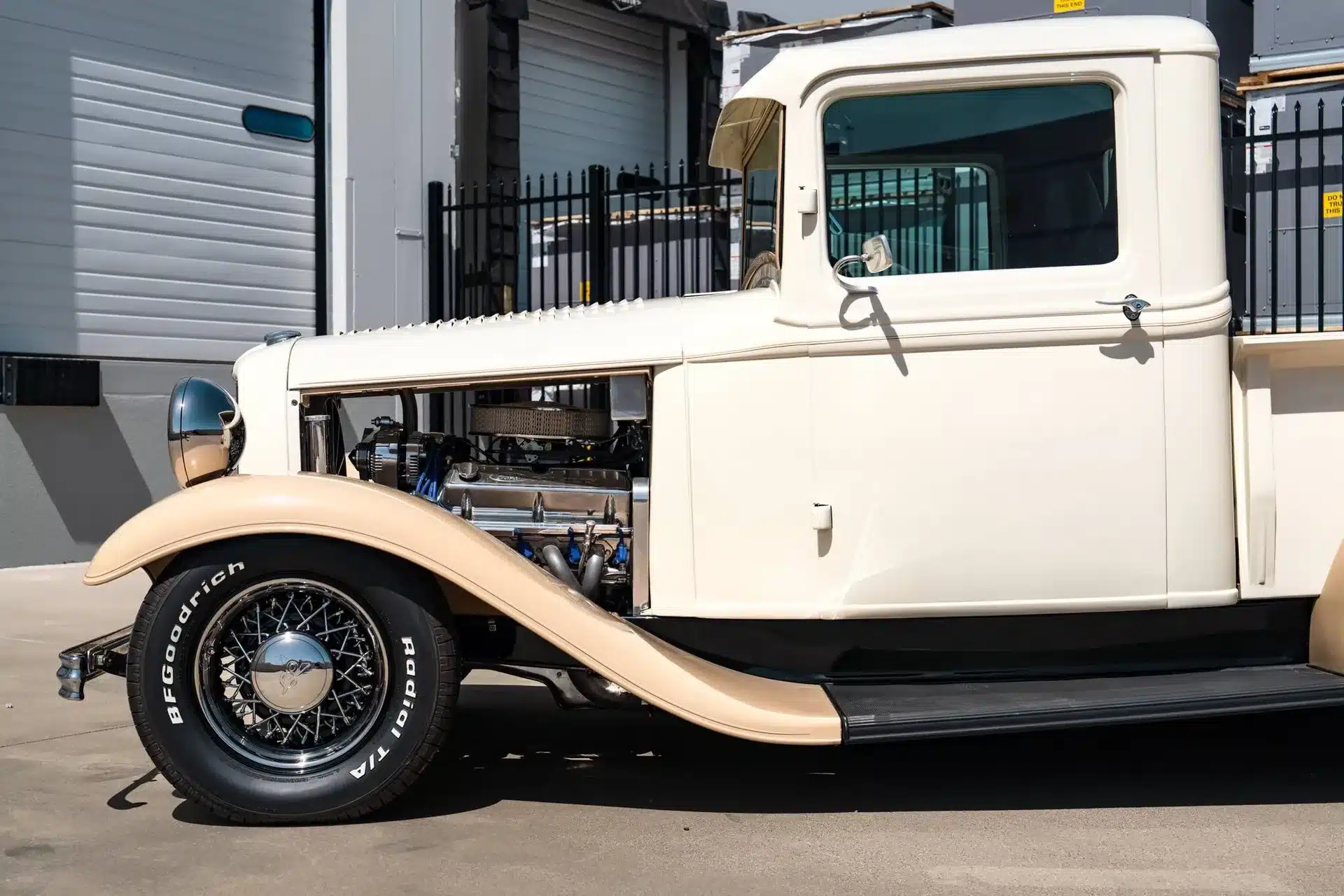 Seitenansicht eines cremefarbenen Ford Pickup von 1932, Fokus auf Motorraum und Fahrerkabine