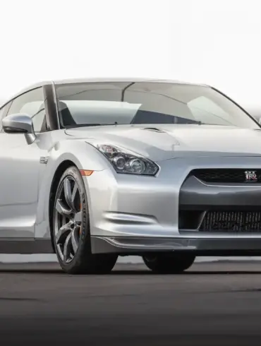 Silberner Nissan GT-R R35 von vorn auf Asphalt vor hellem Hintergrund, Modelljahr 2009.