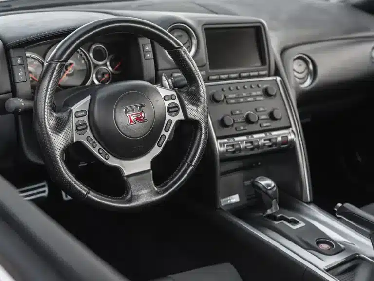 Innenraum eines Nissan GT-R R35 von 2009 mit Sicht auf Lenkrad, Armaturenbrett und Mittelkonsole.