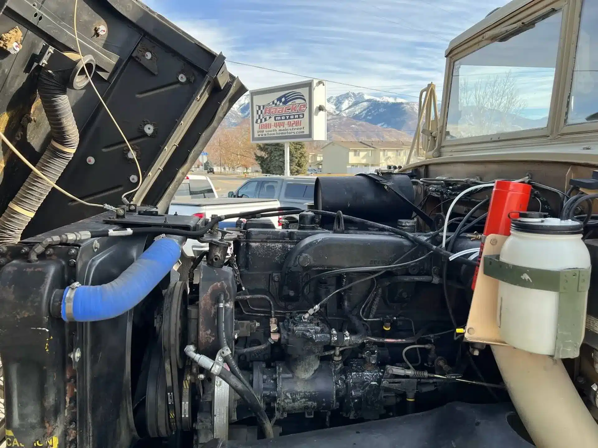 Nahaufnahme des Motors eines AM General M939 Militärlastwagens mit sichtbaren Schläuchen und Bauteilen.