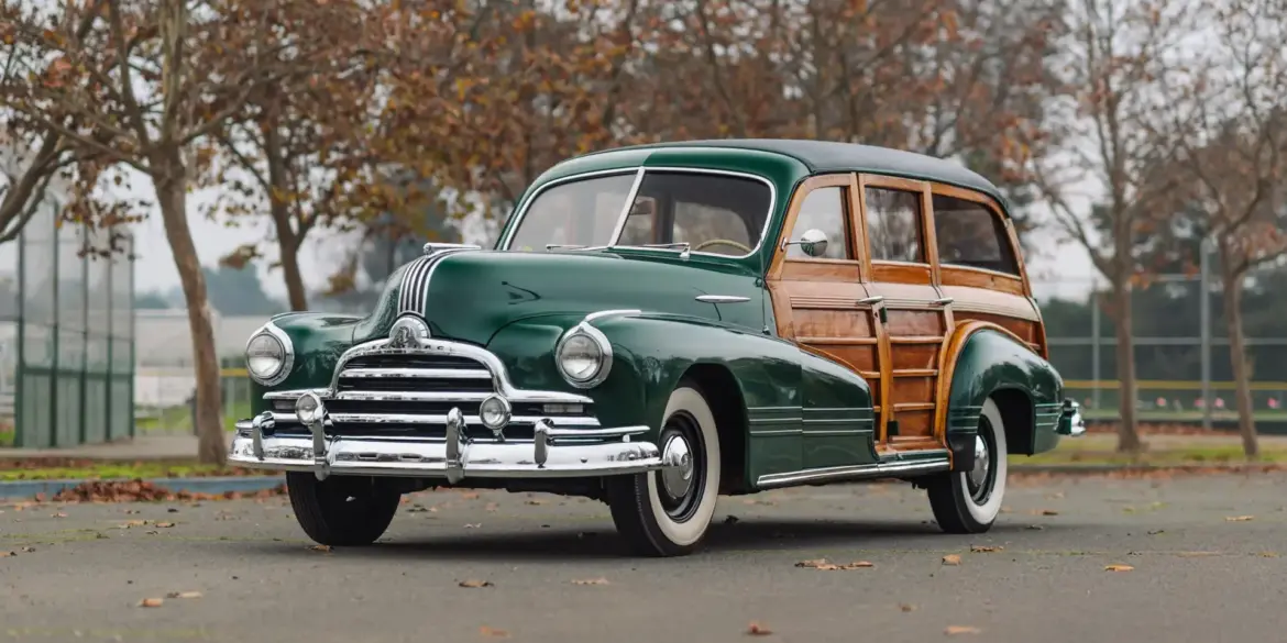 Grüner 1947 Pontiac Streamliner Eight Station Wagon mit markanter Holzkarosserie, im Freien geparkt, seitliche Frontansicht.