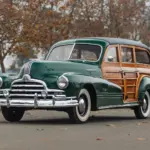 Grüner 1947 Pontiac Streamliner Eight Station Wagon mit markanter Holzkarosserie, im Freien geparkt, seitliche Frontansicht.