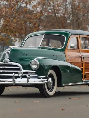 Grüner 1947 Pontiac Streamliner Eight Station Wagon mit markanter Holzkarosserie, im Freien geparkt, seitliche Frontansicht.