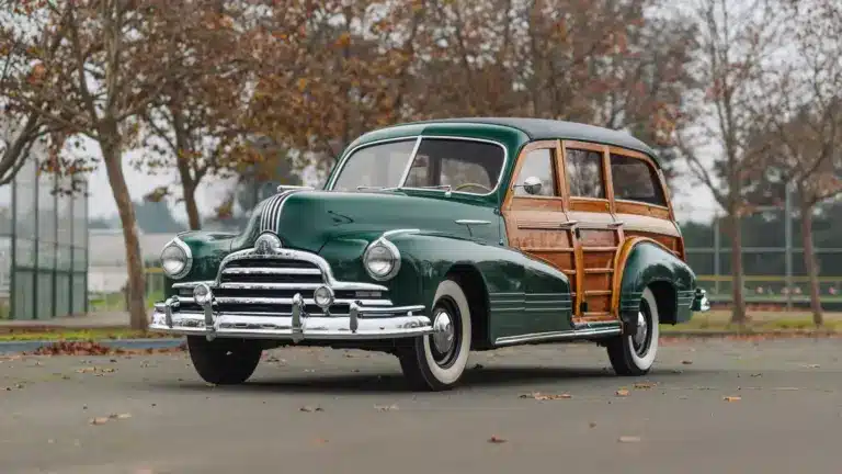 Grüner 1947 Pontiac Streamliner Eight Station Wagon mit markanter Holzkarosserie, im Freien geparkt, seitliche Frontansicht.