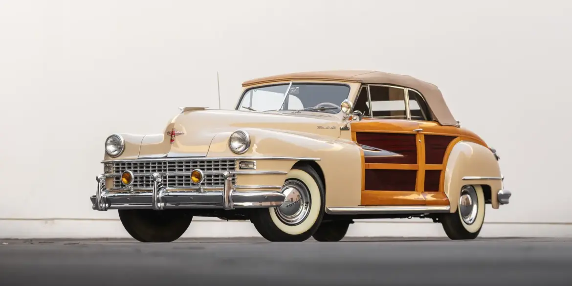 1947 Chrysler Town & Country Convertible mit echter Holzbeplankung und beigem Stoffverdeck, frontal abgelichtet.
