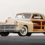 1947 Chrysler Town & Country Convertible mit echter Holzbeplankung und beigem Stoffverdeck, frontal abgelichtet.