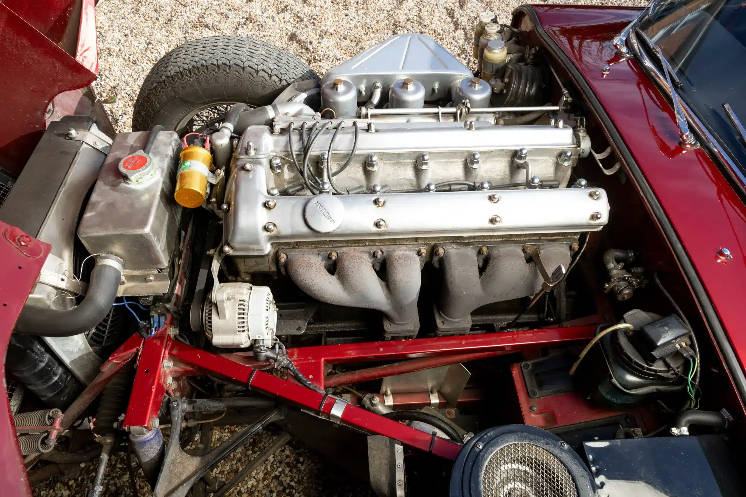 Motorraum eines Jaguar E-Type 3.8 Litre Coupé von 1962 mit sichtbarem Reihensechszylinder.