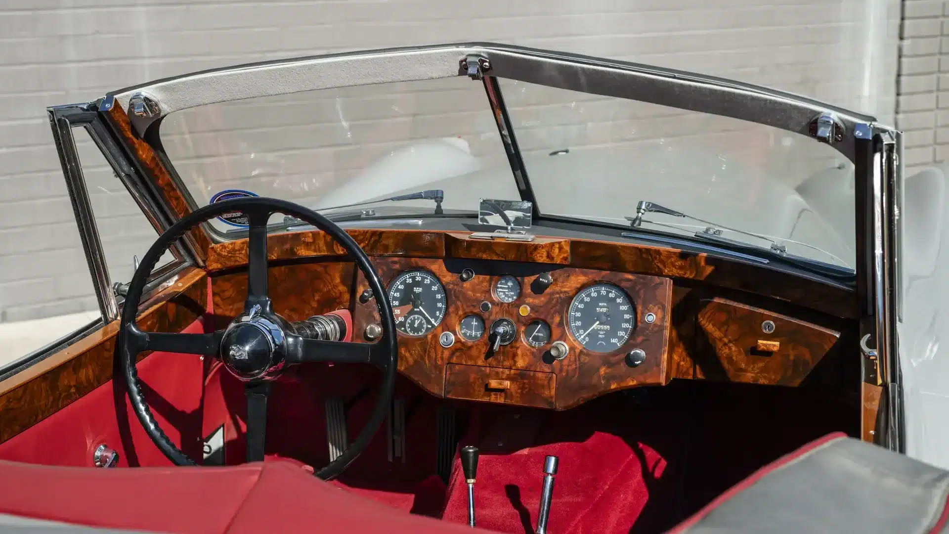Holzverkleidetes Armaturenbrett und rotes Lederinterieur eines Jaguar XK 120 Drophead Coupé von 1953