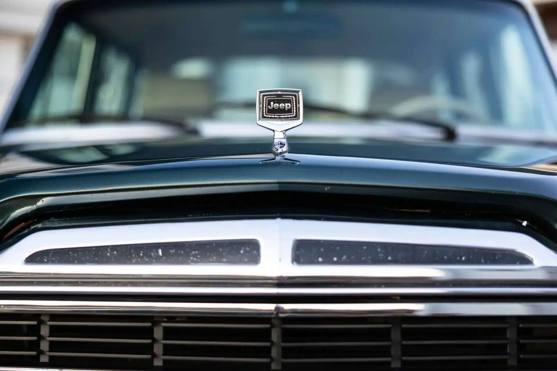 Frontansicht der Motorhaube eines Jeep Grand Wagoneer mit deutlich sichtbarem Jeep-Emblem aus den frühen 1990er Jahren