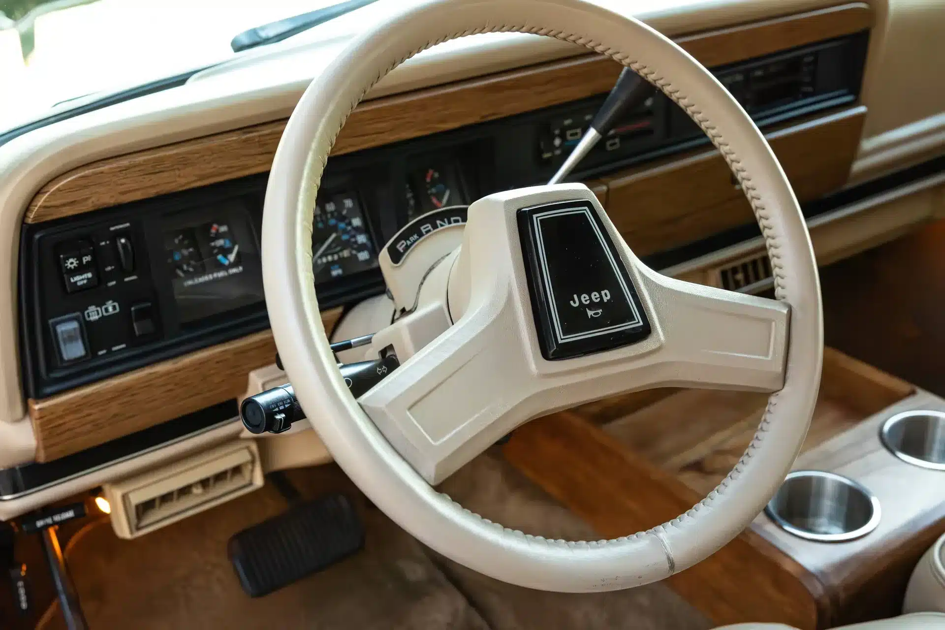 Lenkrad und Cockpit eines Jeep Grand Wagoneer 1991 mit Holzelementen und klassischen Bedienelementen
