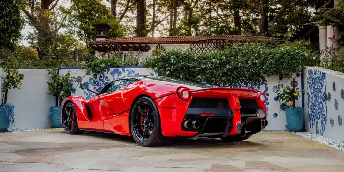 Ferrari LaFerrari 2015 in Rosso Corsa, geparkt in mediterranem Garten, Heckansicht.