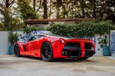 Ferrari LaFerrari 2015 in Rosso Corsa, geparkt in mediterranem Garten, Heckansicht.