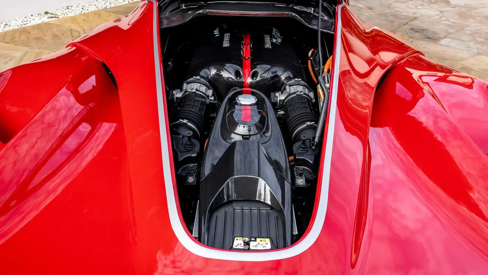Motorraum eines Ferrari LaFerrari mit sichtbarer Carbonabdeckung und V12-Beschriftung