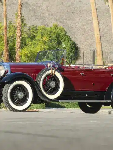 Lincoln Model L Sport Touring by Locke von 1929, kastanienrot mit schwarzen Kotflügeln, offen, mit weißen Wandreifen und zwei seitlichen Ersatzrädern.