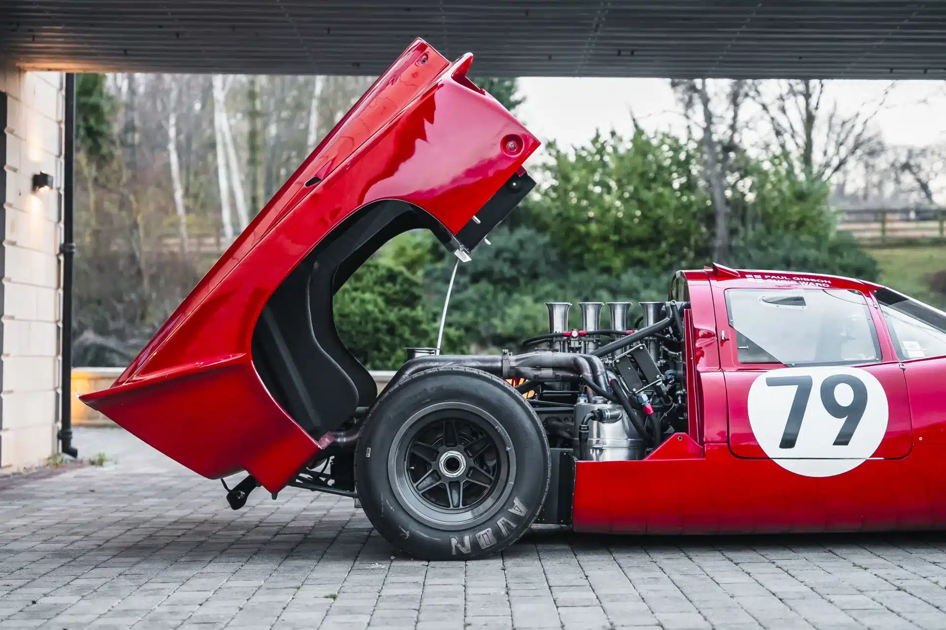 Lola T70 Mk3B Rennwagen, rote Karosserie, mit geöffneter Heckklappe und sichtbarem V8-Motor.