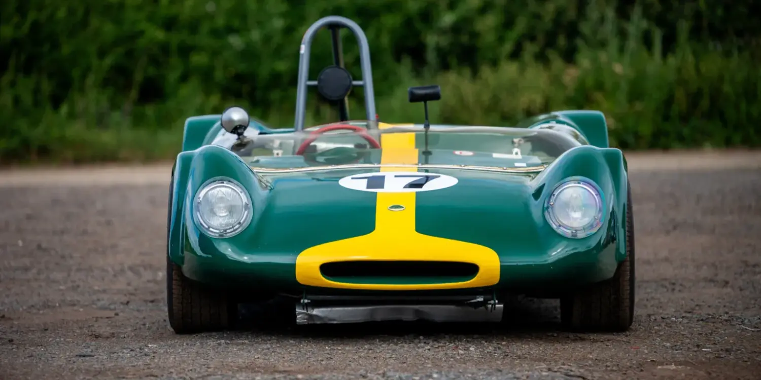 Historischer Lotus 23C Rennwagen in Grün mit gelbem Streifen, frontal aufgenommen.