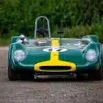 Historischer Lotus 23C Rennwagen in Grün mit gelbem Streifen, frontal aufgenommen.