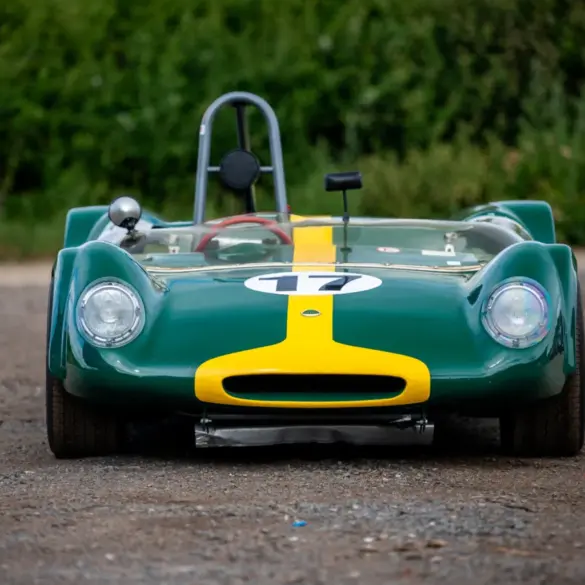 Historischer Lotus 23C Rennwagen in Grün mit gelbem Streifen, frontal aufgenommen.