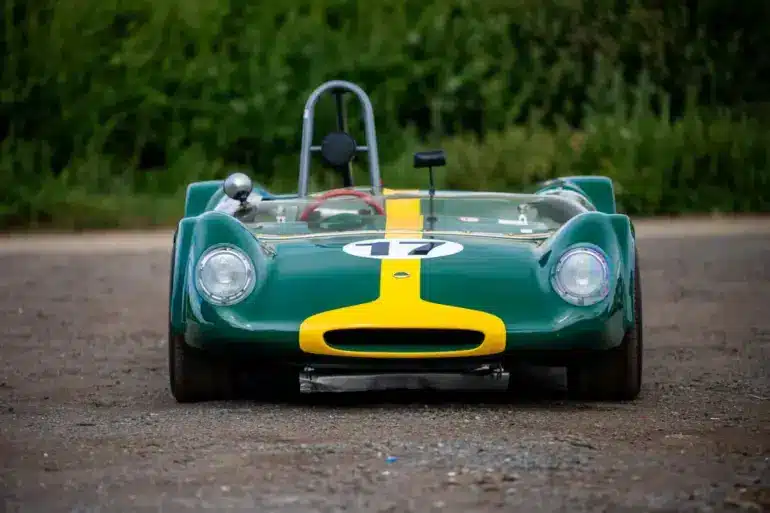 Historischer Lotus 23C Rennwagen in Grün mit gelbem Streifen, frontal aufgenommen.