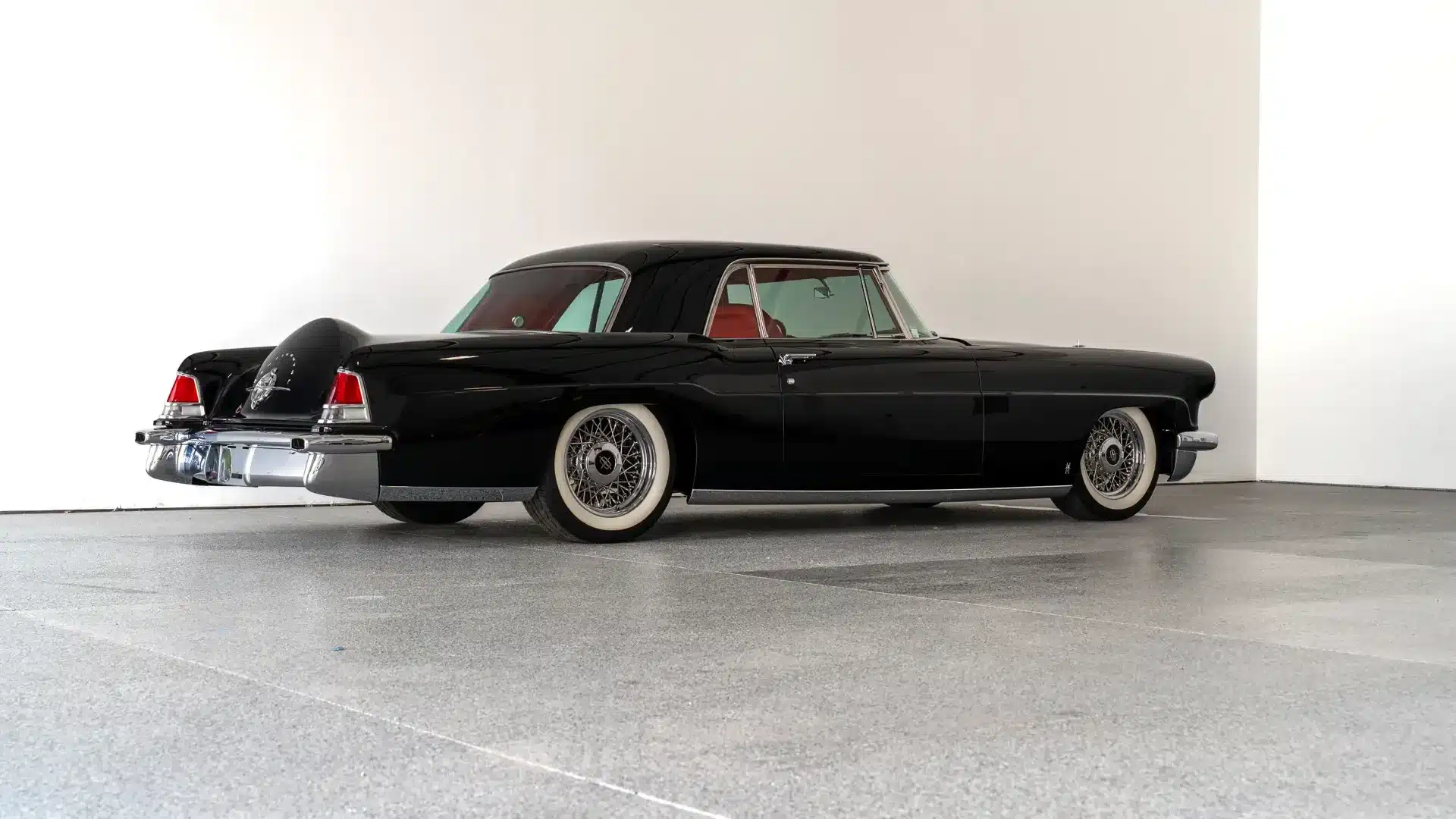 Seitenansicht eines restaurierten und modernisierten Continental Mark II von 1956 in Schwarz mit weißen Wandreifen und Drahtspeichenrädern.