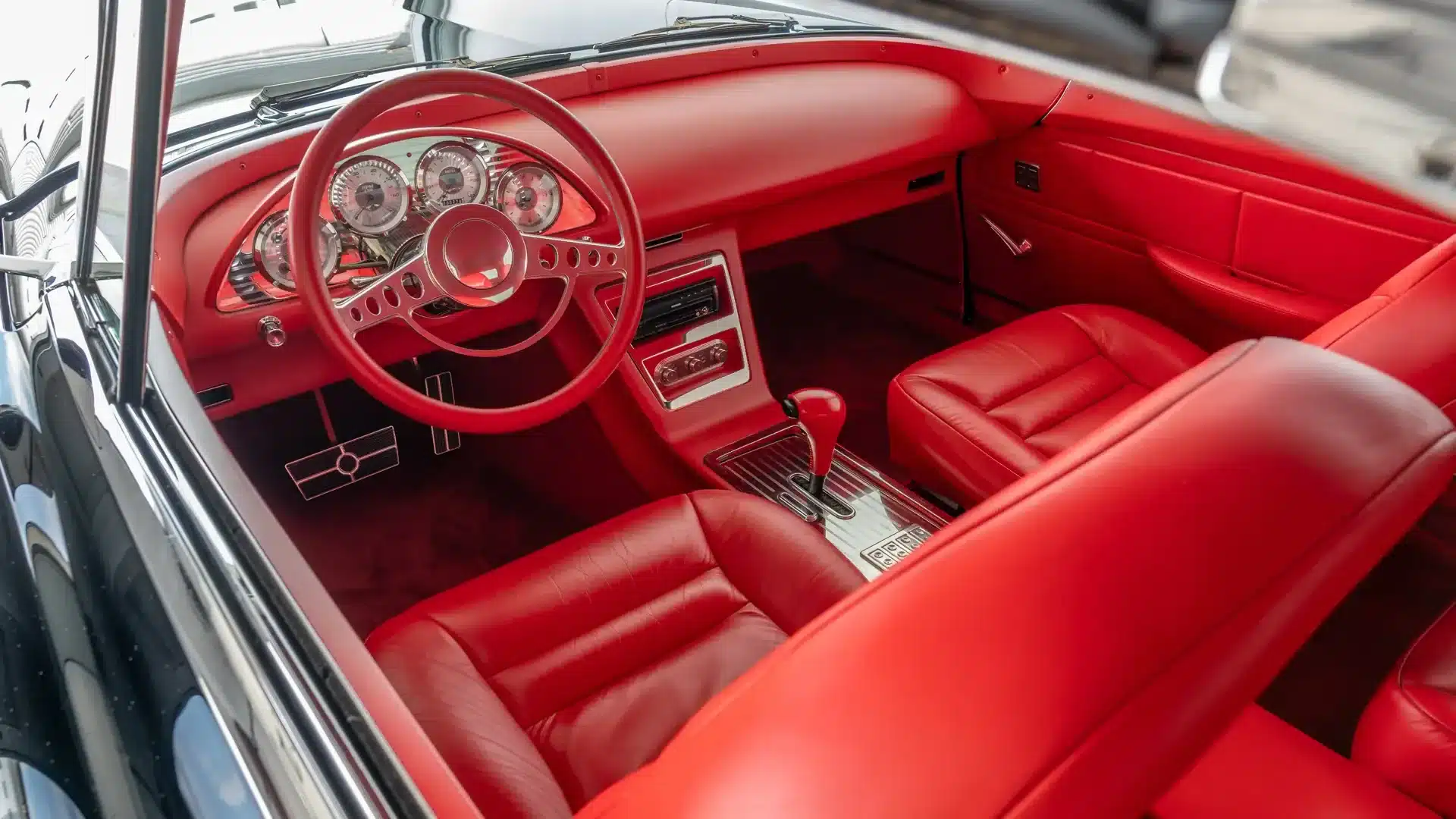 Rotes Lederinterieur eines Continental Mark II Resto-Mods, Blick auf Lenkrad, Armaturenbrett und Schalensitze.