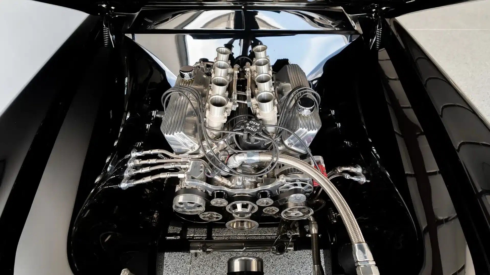 Detailaufnahme des aufwendig modernisierten V8-Motors mit Velocity Stacks im Motorraum eines Continental Mark II von 1956