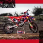 Seitenansicht der GASGAS MC 450F Prado Edition 2025 mit Red Bull-Grafiken und Startnummer 61 auf einem sandigen Untergrund.