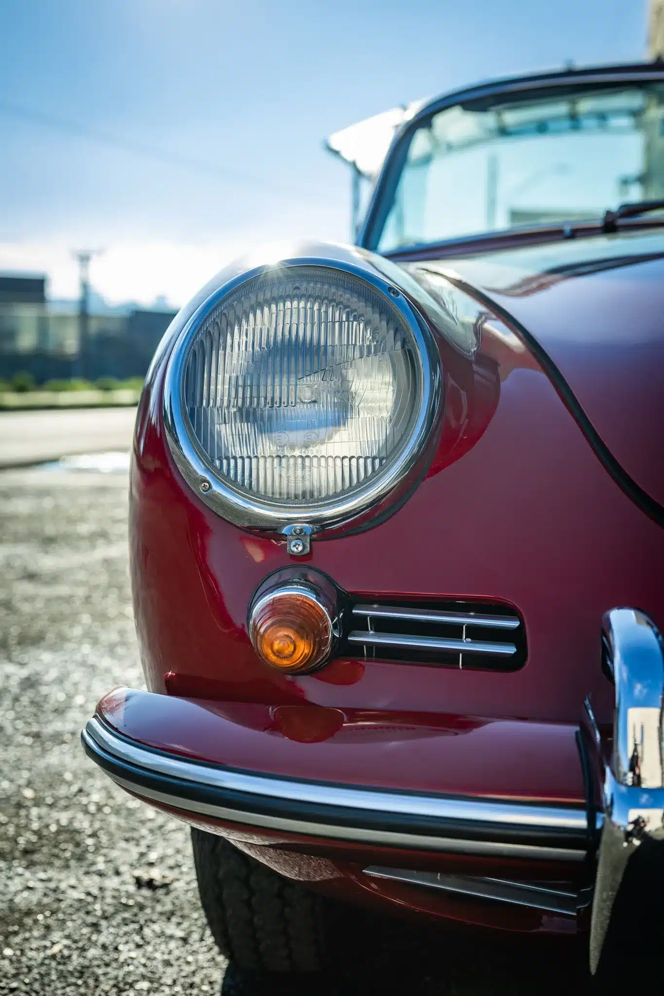 Nahaufnahme des Frontscheinwerfers und der Stoßstange eines Porsche 356C Cabriolet in Ruby Red von 1965