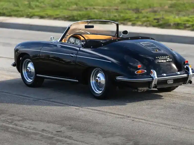 Schwarzer Porsche 356 B Super 90 Roadster by Drauz, Baujahr 1960, auf einer Straße, Aufnahme von schräg hinten.