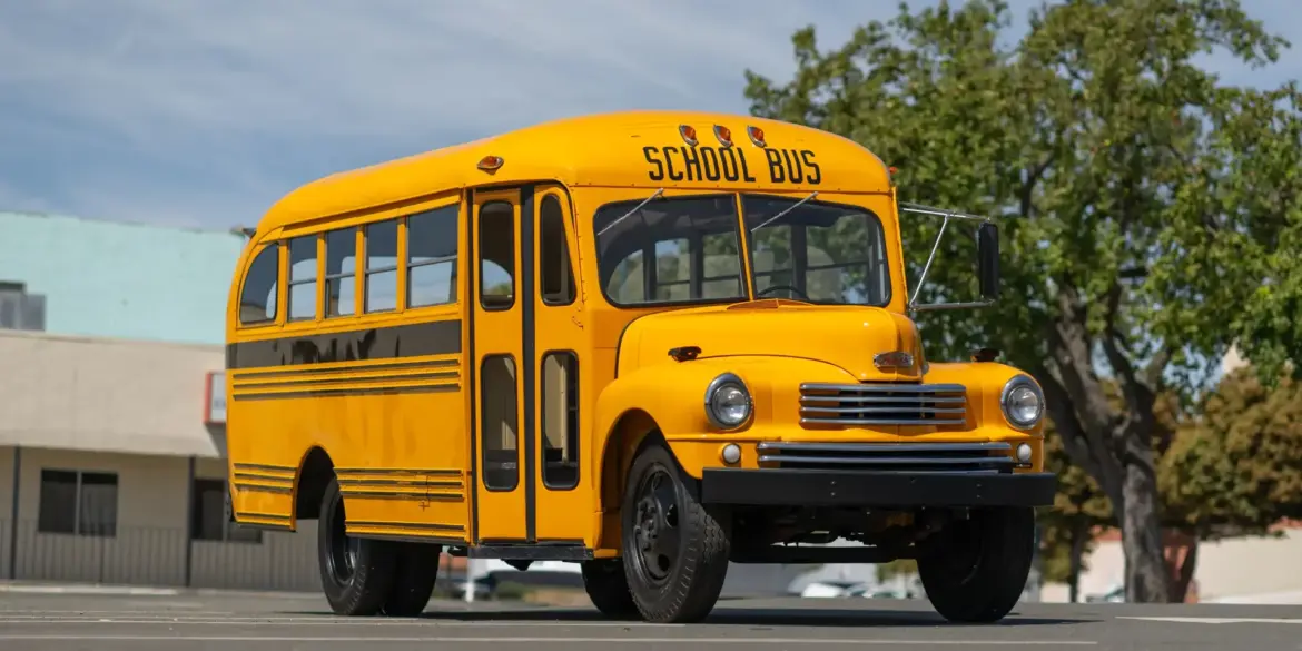 Seitenansicht eines restaurierten, gelb-schwarzen Nash Model 3248 School Bus Baujahr 1949 auf einem Parkplatz