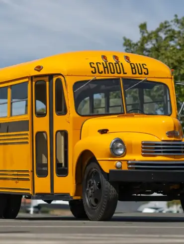 Seitenansicht eines restaurierten, gelb-schwarzen Nash Model 3248 School Bus Baujahr 1949 auf einem Parkplatz