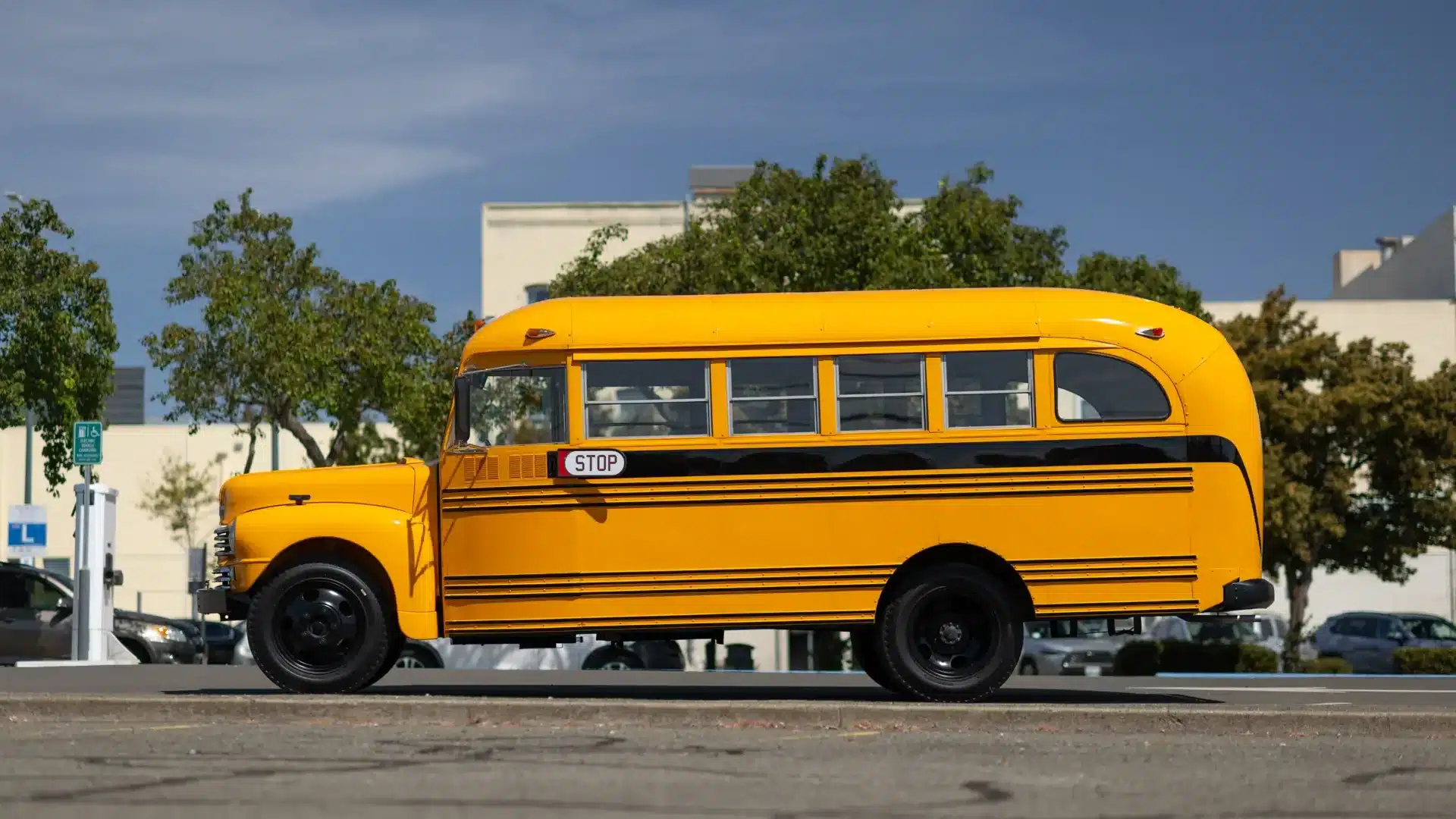 Historischer Nash Model 3248 Schulbus von 1949 in gelb-schwarzer Lackierung mit Stoppschild, fotografiert im Straßenverkehr.
